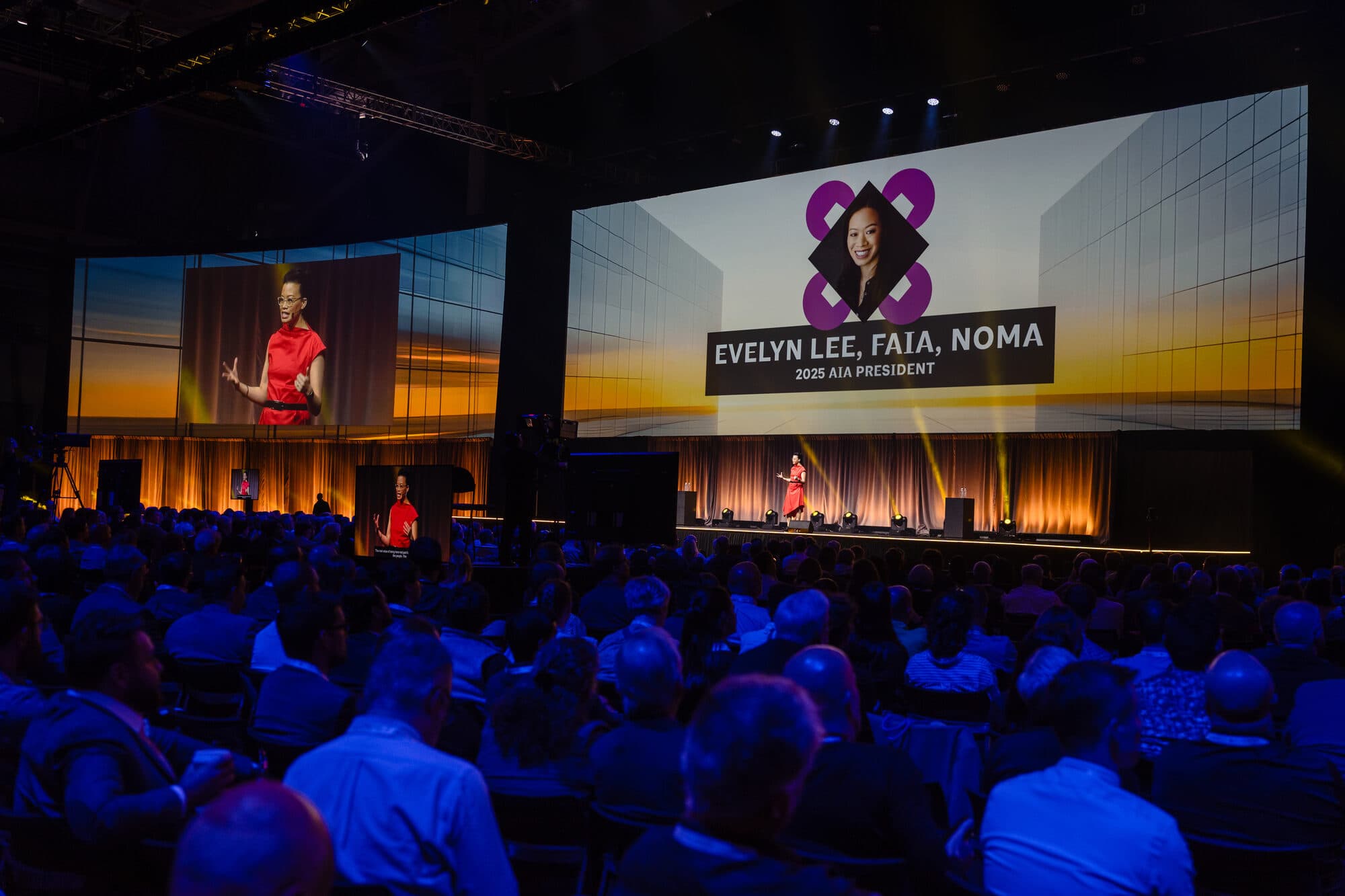 Evelyn Lee delivering the AIA25 Conference mainstage remarks to a full hall, June 2025.